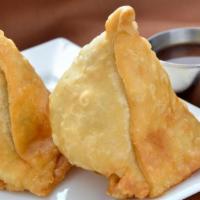 Samosa (2Pcs)-VEGAN · Hand crafted Indian pastry filled with potatoes, peas and ginger garlic. Served with cilantr...