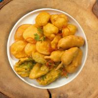 Veggie Pakora Pleasure · Mixed veggies (spinach, onions, potatoes and cauliflower) dipped in a spicy butter. Vegan.