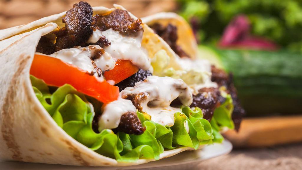 Chicken Gyro Wrap · Thin sliced of seasoned boneless chicken,
stacked and cooked on a vertical rotisserie
served on a warm lavash bread filled with
lettuce, tomato, onions, and tzatziki sauce.