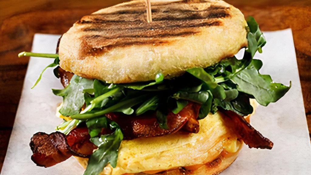 The Grove Breakfast Sandwich · soft scrambled eggs, American heritage ham or applewood smoked bacon, aged sharp cheddar, wild arugula, our green herb sauce, Wolferman’s english muffin