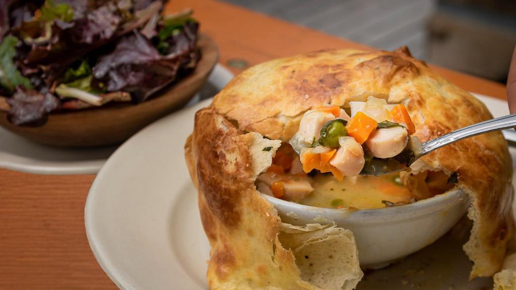 The Grove's Chicken Pot Pie · house brined roast chicken breast in a rich chicken broth, carrots, peas, topped with a rolled handmade savory oregano pastry crust; with a side of organic baby lettuces