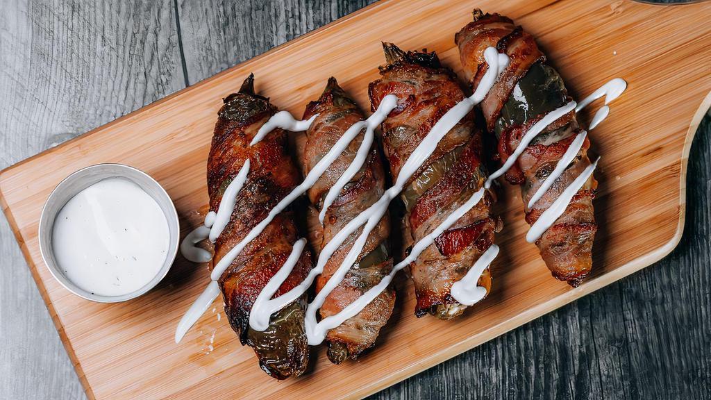 Jalapeño Poppers · Stuffed jalapeño with beef and cream cheese wrapped in crispy bacon.