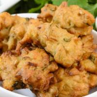 Vegetable Pakora · Freshly prepared potato and onion fritters, deep-fried and served with tamarind and mint sau...