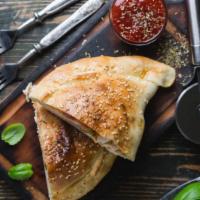The Grilled Chicken Calzone · Classic crescent shaped calzone filled with mozzarella, ricotta cheese, and grilled chicken ...