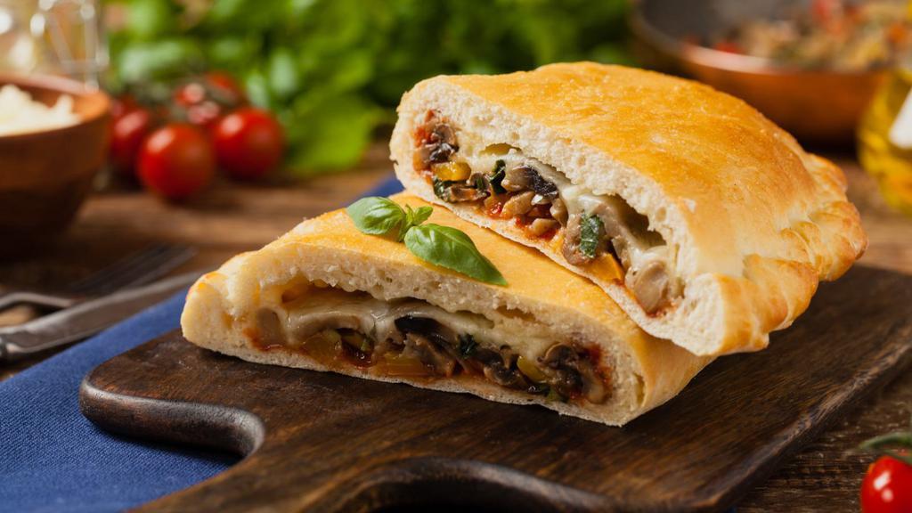 The Mushroom Tomato Calzone · Classic crescent shaped calzone filled with mozzarella, ricotta cheese, mushroom, and tomatoes baked to perfection, then sprinkled with garlic, oregano, and parmesan cheese.