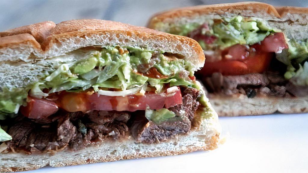 Torta · Choice of meat with grilled onions, toasty roll with beans, cheese, lettuce, tomato, mayo, and avocado.