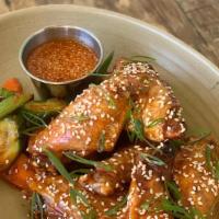 Sesame Chicken Wings · Crispy chicken wings, gochujang, green onion, quick pickles, sesame-honey dipping sauce (8 p...