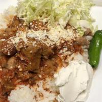 Morisqueta · steamed rice with pork meat in red sauce, beans, cabbage, sour cream, and cheese.