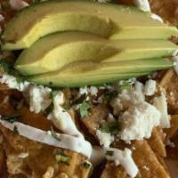 Chilaquiles Rancheros · Homemade chips tossed with eggs, ranchera sauce, sour cream, avocado and queso fresco.