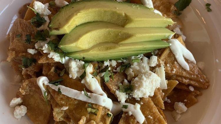 Chilaquiles Rancheros · Homemade chips tossed with eggs, ranchera sauce, sour cream, avocado and queso fresco.