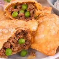 Lamb Samosa · Triangular Fried pastry with a savory filling of spiced green peas and minced lamb.