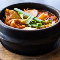 Kimchi Stew (Dinner) · With beef, tofu, glass noodles, onions, and sliced rice cakes. Broth is made with kelp and v...