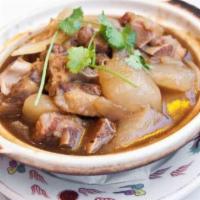 Ox Tail Stew in Clay Pot · Hearty pieces of stewed ox tail and turnips in a clay pot.