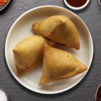 Samosas · Two pieces. Deep fried pastry shells, stuffed with potatoes and peas.