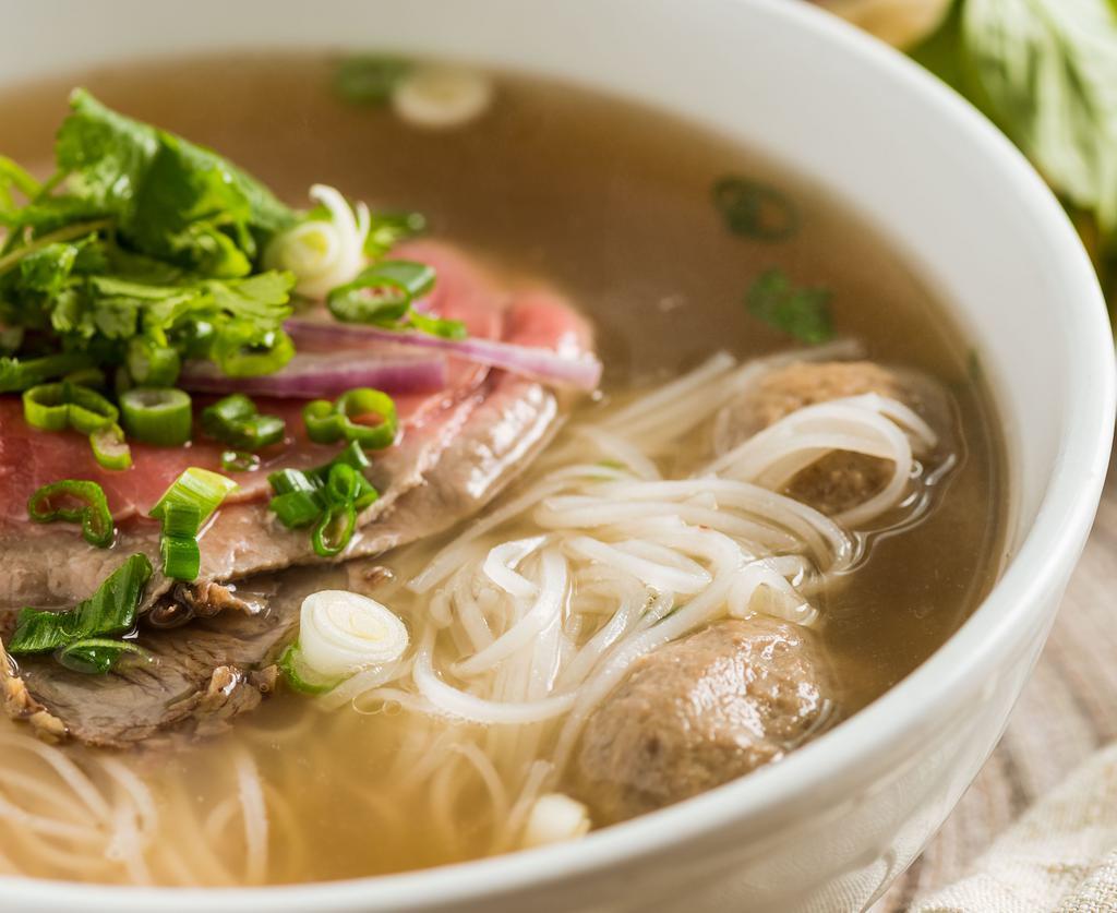 #32. Vietnamese Beef Noodle Soup (Pho) · Combination of rare steak, well done flank, beef meat balls, red onions, cilantro in traditional Vietnamese beef soup served with bean sprouts, basil, lemon and chill peppers.