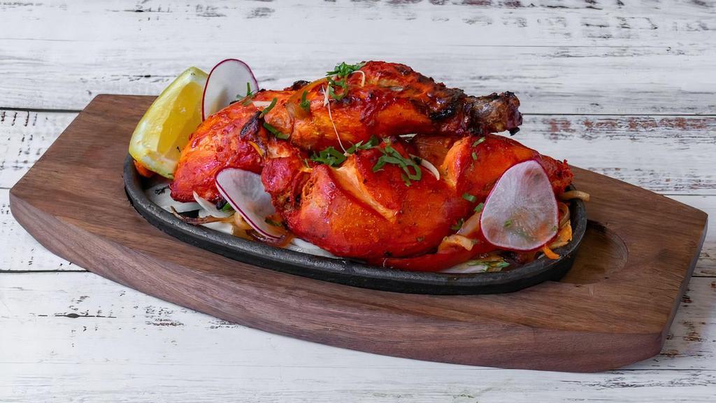 Tandoori Chicken · Half chicken leg and breast marinated in lemon juice, yogurt, ginger, garlic, and other Indian spices. Cooked in a clay oven.