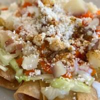 Tacos Dorados - 4 · Crispy corn tortillas filled with chicken and carrots. Topped with lettuce, diced carrots an...