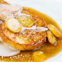 Bananas Foster · Brioche French Toast topped with caramelized bananas, fresh whipped cinnamon cream & powdere...