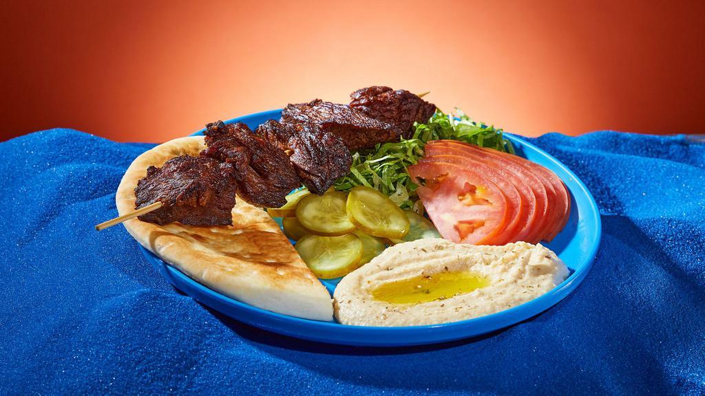 Beef Kebab Platter · Marinated cubes of beef grilled on a skewer. Served with rice, lettuce, tomato, pickles, and pita.