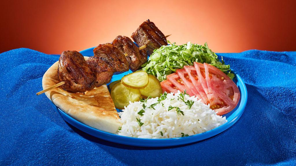 Lamb Kebab Platter · Marinated cubes of lamb grilled on a skewer. Served with rice or hummus, lettuce, tomato, pickles, and pita.