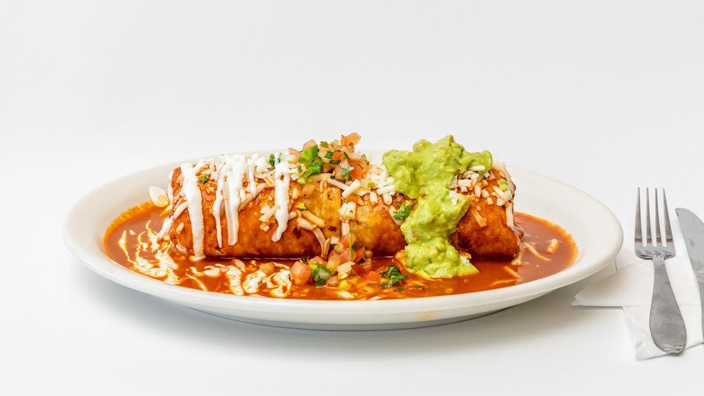 Burrito Mojado · Choice of meat, rice, beans. Topped with red sauce, melted cheese, sour cream, guacamole jalapenos, onions, cilantro and tomatoes.