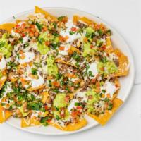 Super Nachos · Homemade crunchy tortilla chips served with a choice of meat, beans, cheese jalapenos, guaca...