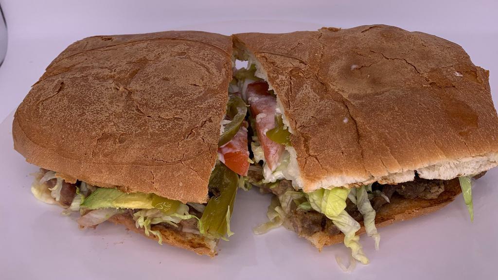 Torta · Bread filled with your choice of meat, melted cheese, fried beans, sour cream, lettuce, tomatoes, onions, jalapeño, slices of fresh avocado.