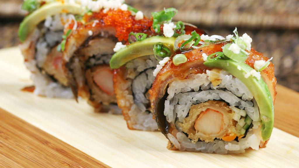 Dragon Roll · Shrimp tempura, crab meat and cucumber topped with eel, avocado, tobiko, and eel sauce.