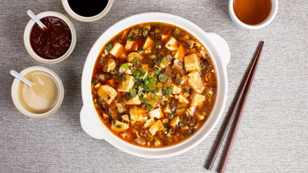 Ma Po Tofu 麻婆豆腐 · Tofu simmered and cooked in a spicy numbing curry and garnished with spring onions.