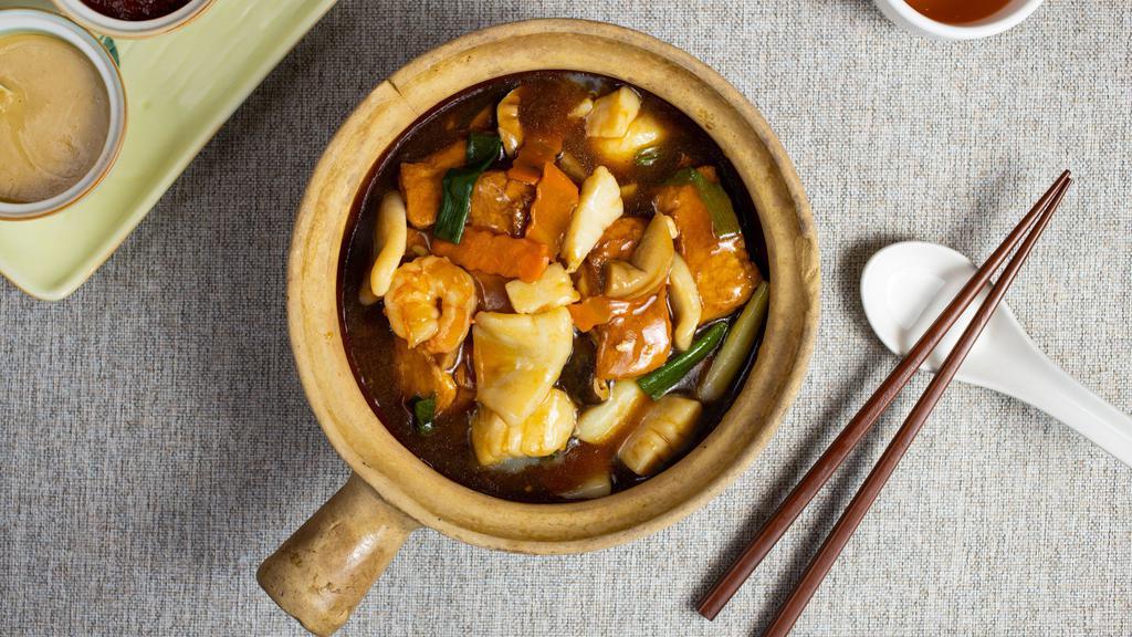 Braised Tofu with Seafood 海鮮豆腐煲 · Braised tofu and seafood cooked in a clay pot and garnished with veggies.