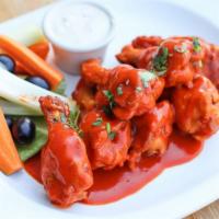 Buffalo Chicken Wings · Tossed in a spicy red chili sauce served with crudité and Bleu cheese dressing.