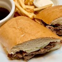 French Dip · Shaved tri-tip with melted Jack cheese on a soft french roll with sides of au jus and prepar...