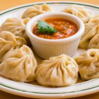 Chicken Momo · Twelve handmade chicken dumplings steamed and served with a special tomato chutney.