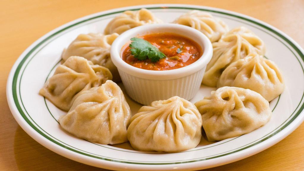 2. Vegetable Momo (8 Pcs) · Steamed dumpling filled with minced cabbage, cauliflower, spinach, cheese, onion, cilantro, and nepali herb and spices, served with tomato chutney.