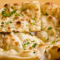 56. Garlic Naan · Tandoori breads topping with garlic and cilantro.