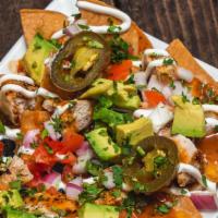 Grilled Chicken Nachos · Black beans, avocado, tomatoes, cilantro, red onions, cheese blend, sliced jalapenos, chipot...
