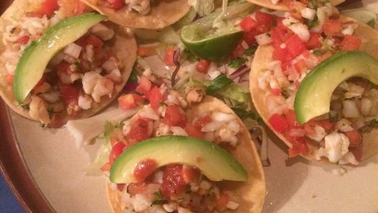 Tostadas de Ceviche Estilo Tepa · Fish ceviche; raw fish marinated with lime juice, onions, tomatoes, cilantro. Topped with avocado slices.