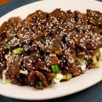 Xiao Loong Beef · Sliced flank steak marinated in a garlic-infused sweet and peppery sauce stir-fried, and pla...