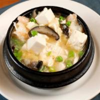 Clay Pot Prawns and Tofu · Prawns and diced tofu simmered in white wine, garlic, peas, and mushrooms. Served in a sizzl...