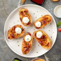 Loaded Potato Skins · Baked potato skins filled with cheddar cheese, bacon, scallions, and topped with sour cream.