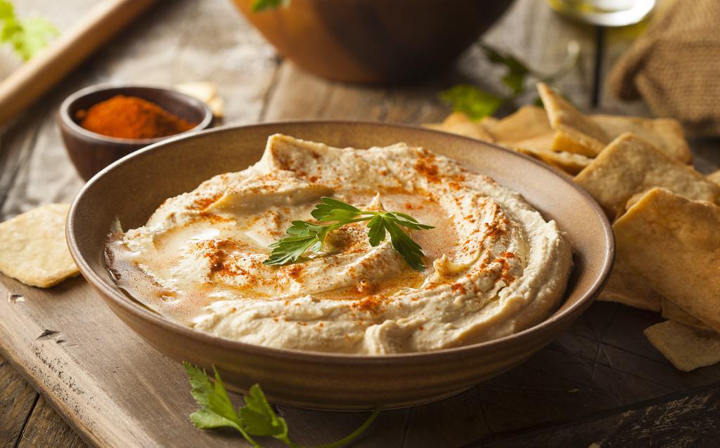 Hummus · A delightful dip of mashed Garbanzo beans, Tahini, garlic, lemon juice, and olive oil.
