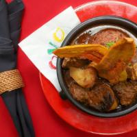 Curry Goat · Peas and rice, fried plantains, micro culantro