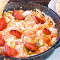 Menemen · Three scrambled eggs with tomato, onion, and bell pepper.
