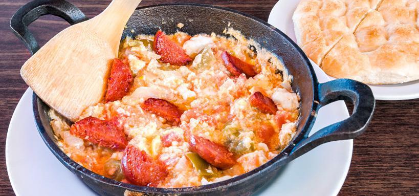 Menemen · Three scrambled eggs with tomato, onion, and bell pepper.