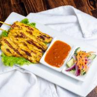 Satay Chicken · Skewered sliced marinated chicken with Thai herbs served with peanut sauce and cucumber salad.