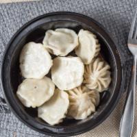 Chicken Mo:Mo Sizzler (8) · Steamed chicken dumplings served in a sizzling cast iron plate with salad and homemade tomat...