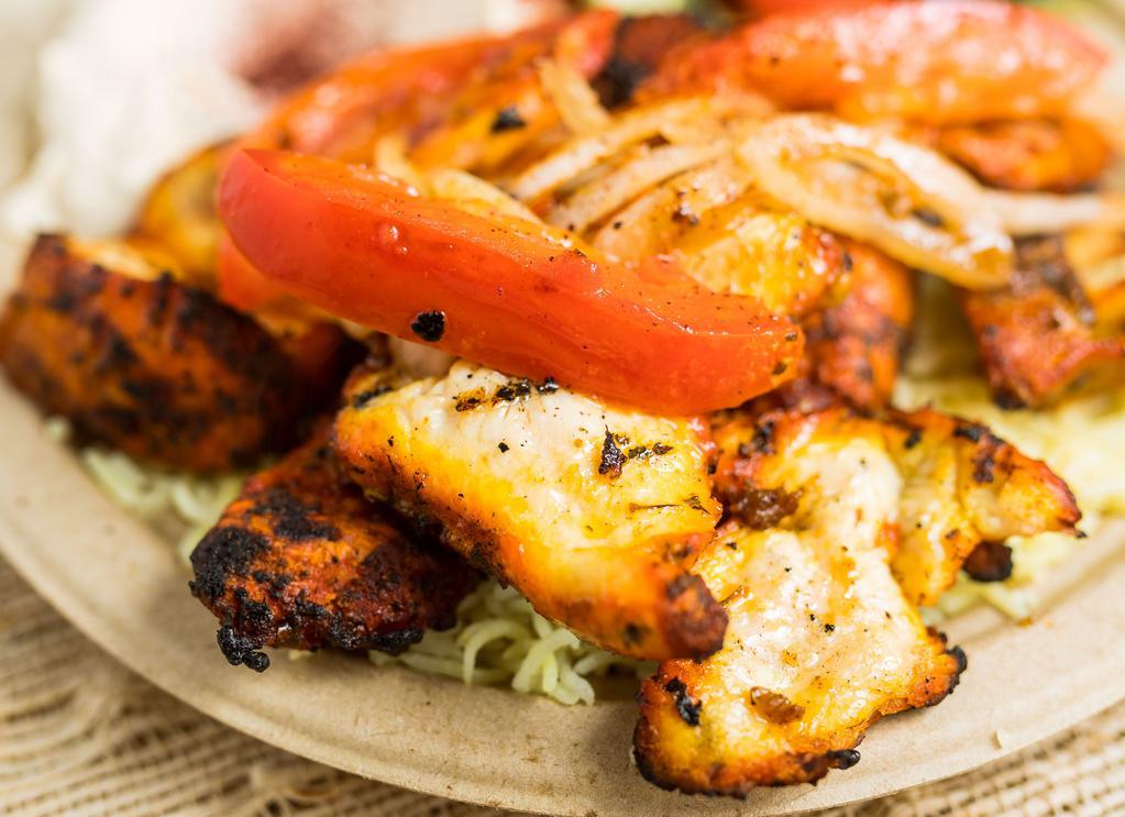 Chicken Kabob · Tender chicken cubes marinated with Mediterranean spices and grilled to perfection, served with grilled tomatoes, onion, hummus, Mediterranean salad, rice and warm pita bread.