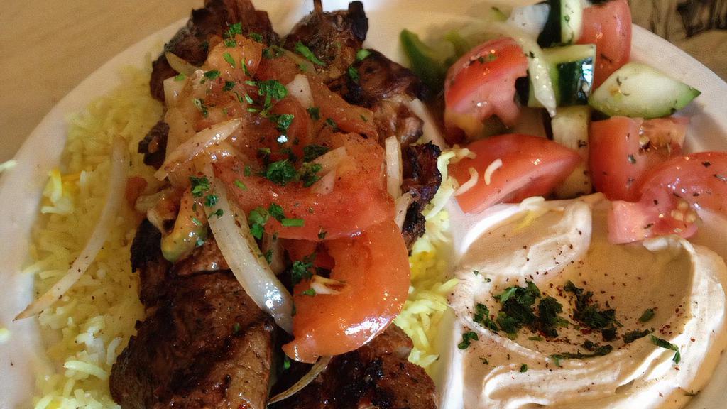 Lamb Kabob · Tender lam cubes marinated with Mediterranean spices and grilled to perfection, served with grilled tomatoes, onions, hummus, Mediterranean salad, rice and warm pita bread.