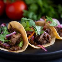 Tacos de Rabo de Toro · sherry braised oxtail tacos with pickled habanero onions and cilantro aioli on a flour and c...