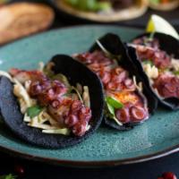 Tacos de Pulpo Gallego · galician style octopus with cabbage, oyster tartar, and crispy garbanzos on squid ink tortil...